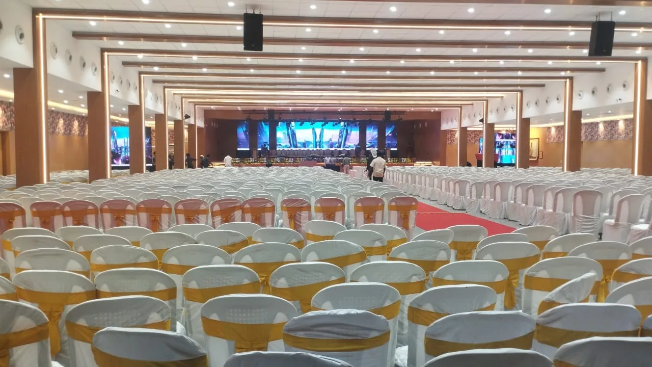 Large event hall set up with seating beneath ceiling air outlets